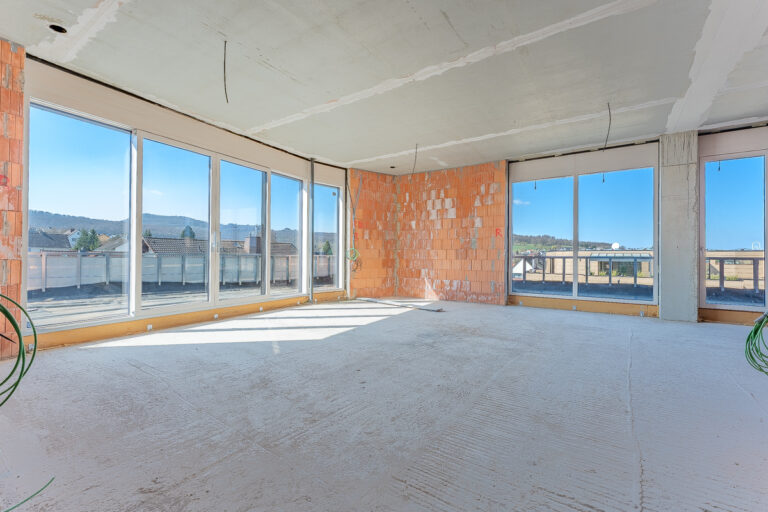 Wohnzimmer mit offener Küche und Zugang zur Dachterrasse