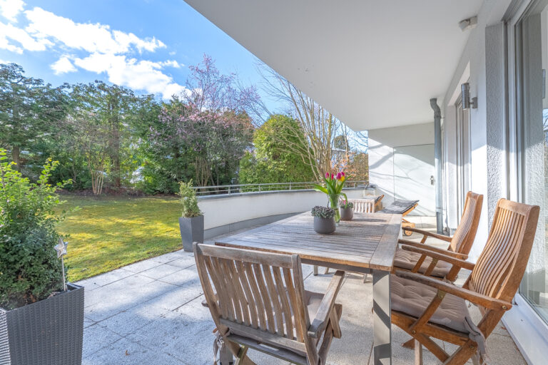 Blick vom Wohnbereich auf die Terrasse mit Garten