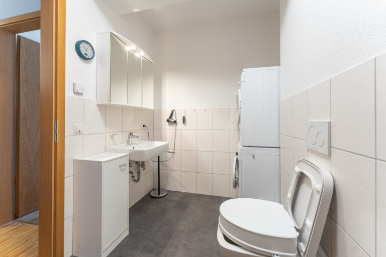 Badezimmer mit Dusche und Platz für Waschmachien und Trockner