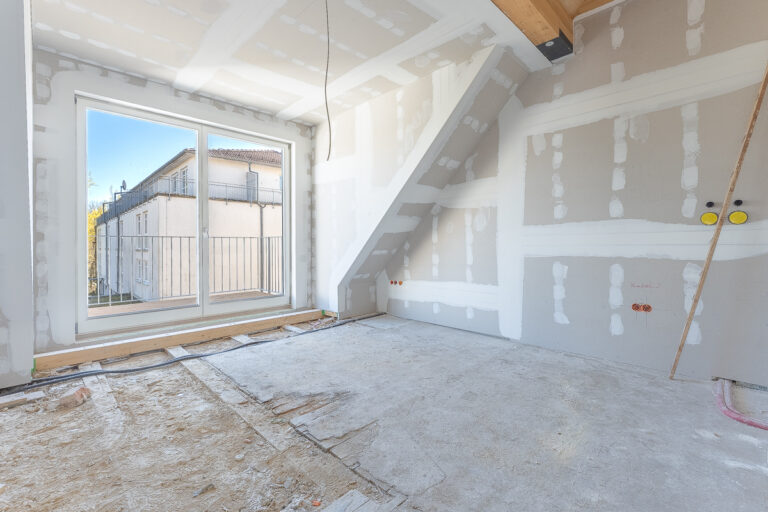 Wohnbereich mit Küchenzeile und Zugang zum Balkon