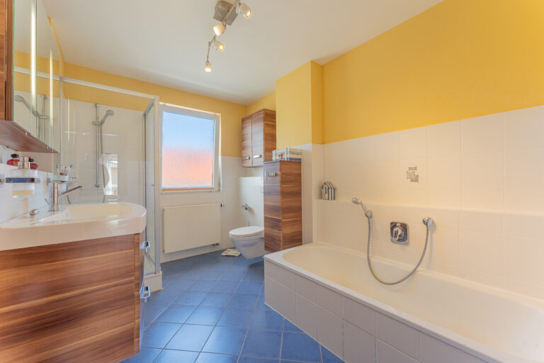 Badezimmer mit Badewanne und Dusche