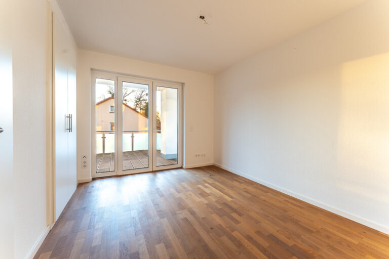 Schlafzimmer mit Zugang zum teilüberdachten Balkon