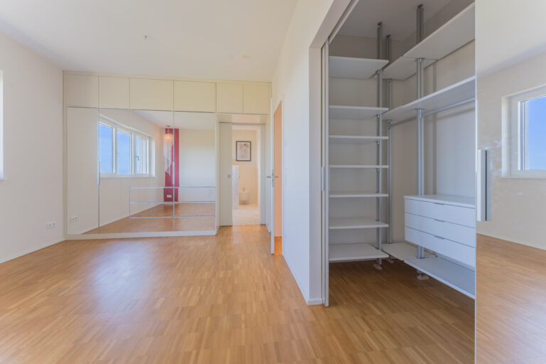 Master-Schlafzimmer mit begehbarem Schrank und Zugang zum Badezimmer