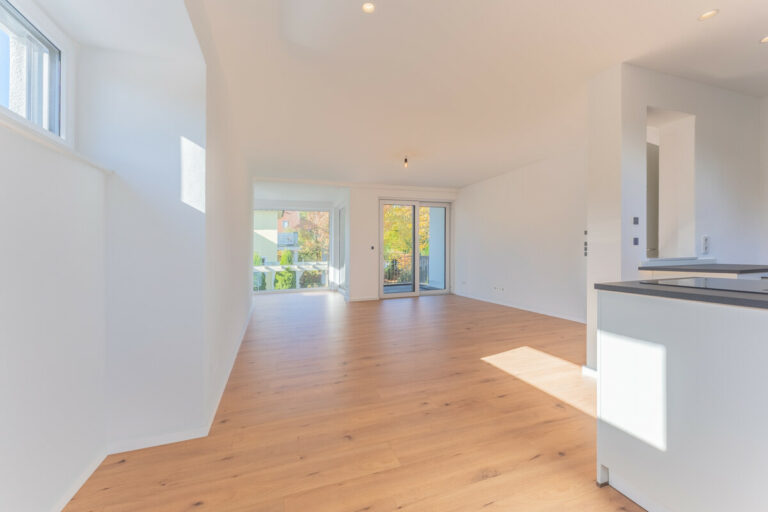 Blick vom Essbereich über die Küche in den Wohnbereich