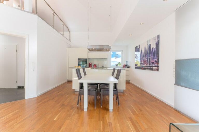 Blick aus dem Wohnbereich auf den Essbereich mit offener Küche