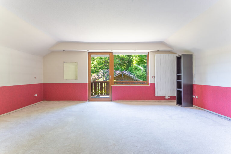 Schlafzimmer 2 im Dachgeschoss mit Balkon und Blick in den Garten