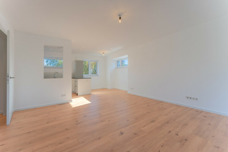 Blick vom Balkon zum Wohn- und Essbereich mit offener Küche