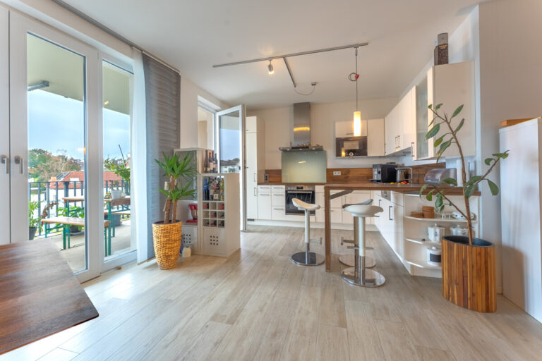 Blick aus dem Wohn- und Essbereich zur Küche mit Ausgang zum Balkon