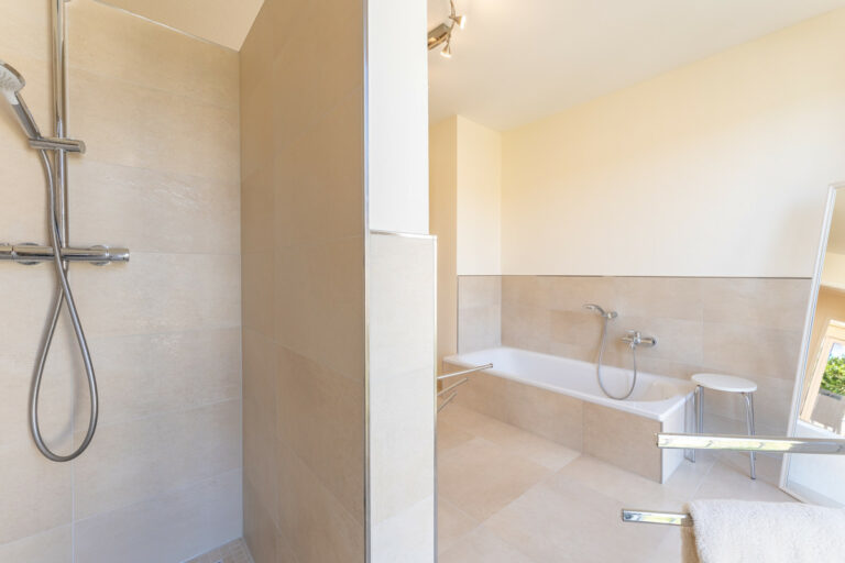 Badezimmer mit Badewanne und Dusche