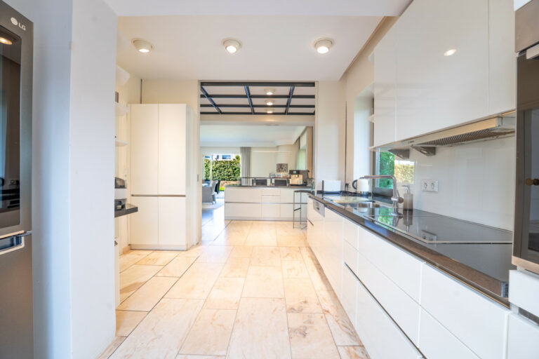 Küche mit Zugang zum Wohnbereich, dem Flur und dem Carport