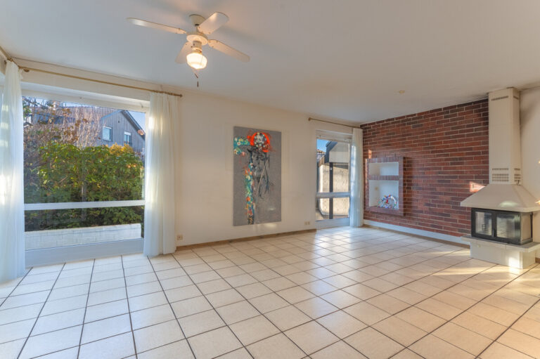 Wohnzimmer mit Kamin und Wintergarten