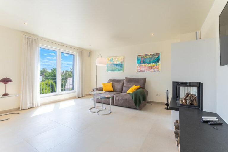 Wohnzimmer mit Kamin und Zugang zur Terrasse