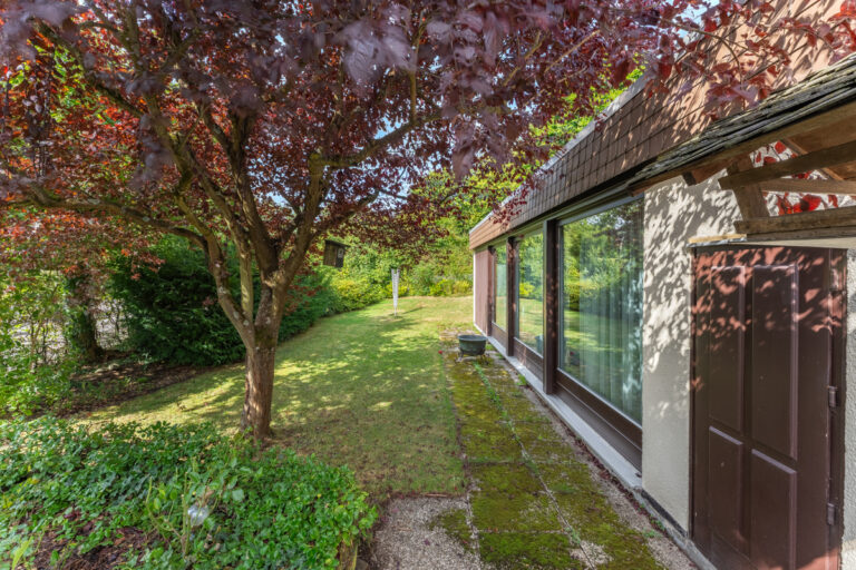 Blick von der Terrasse zum Garten und dem Poolhaus